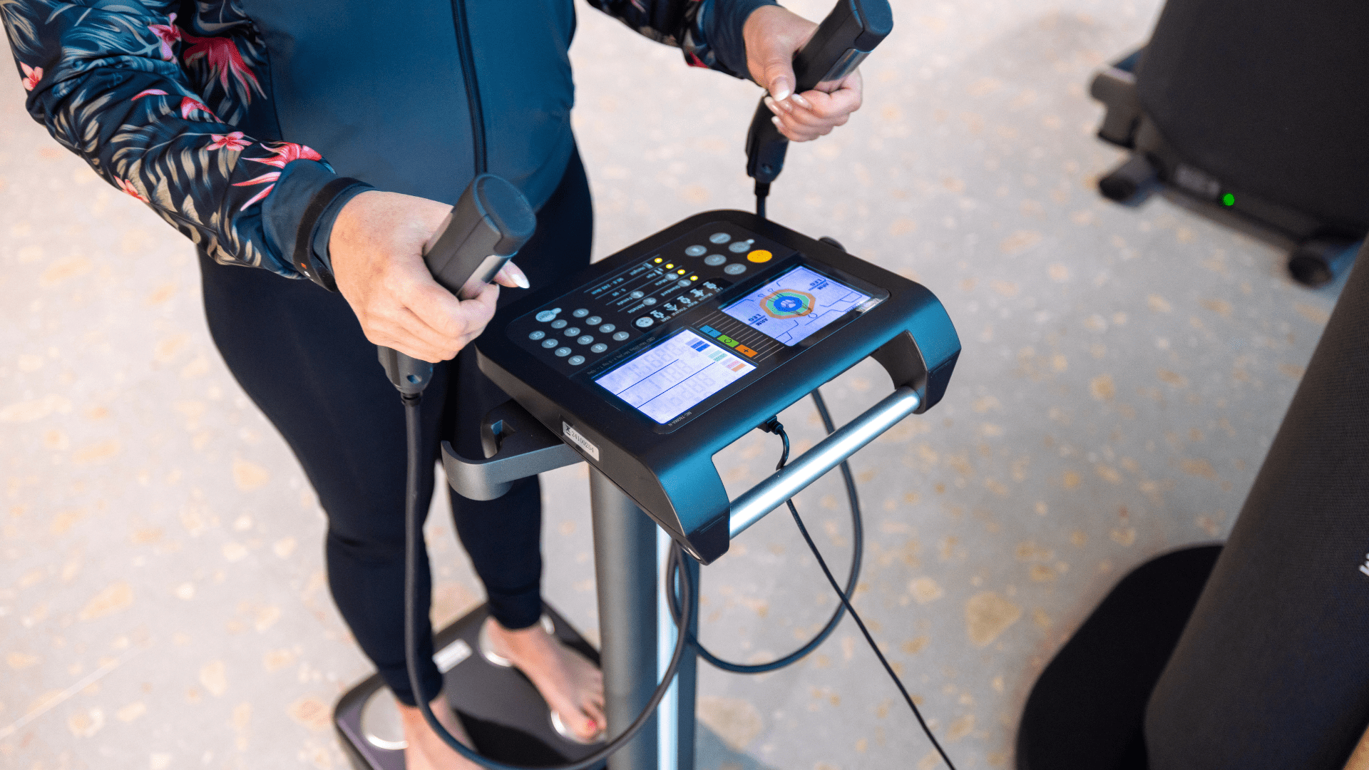 Myhubin asiakas tekemässä kehonkoostumusmittausta Tanita laitteella